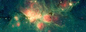 Cat's Paw nebula, in the green regions radiation of hot stars induces fluorescence of PAHs (Source: NASA/JPL-Caltech, Wikipedia)